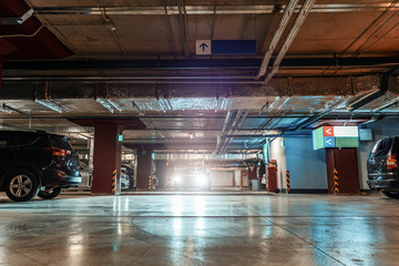 Parking Garage, Illuminated Underground Car Park Lots under modern Mall with Vehicles