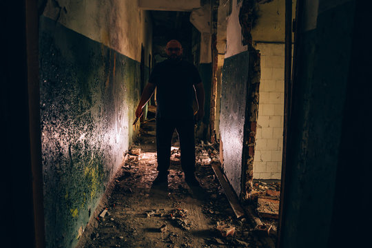 Killer Silhouette with Knife in hand in dark corridor. Crime scene and trash horror maniac