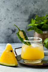 Spicy golden watermelon margarita cocktail with jalapeno and lime. Mexican alcoholic drink for Cinco de mayo party