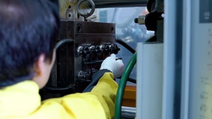 Operator takes out the plastic product from the forging apparatus