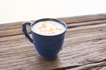 Hot latte coffee cup with on wooden table.