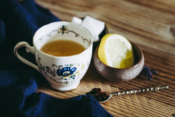 Thé au citron et badiane dans une tasse en céramique vintage posé sur une table en bois