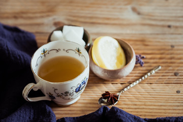 Thé au citron et badiane dans une tasse en céramique vintage posé sur une table en bois