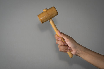 Female holding wooden hammer in hand.