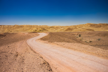desert dry wasteland valley horizon scenic landscape view with lonely curved ground trail in Middle East hot environment 