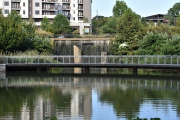Fototapeta na wymiar Park with lake, waterfall and pedestrian walkway