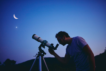 Astronomer with a telescope watching at the stars and Moon. My astronomy work.