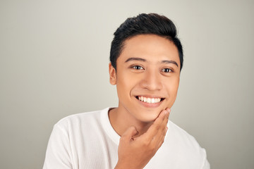 Handsome Asian man touching his face close up portrait studio on white background