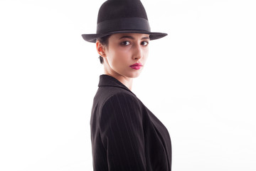 Side view portrait of gorgeous young female wearing a retro black hat in studio over white background