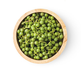 fresh Szetchwan pepper in wood bowl on white background. top view
