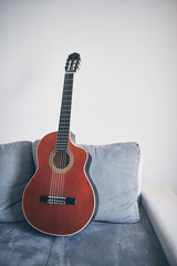 Obraz na płótnie Canvas Acoustic guitar on a living room couch / sofa.