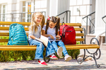 Back to school. Happy children ready for primary school. Pupil on first day of classes. girl with backpack and book on backyard. Education for kindergarten and preschool kids.