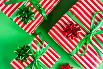 Christmas gift boxes simple pattern background. Festive boxes with Christmas presents, decorated with bright bows with ribbons. Flatlay, above copy space