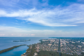 Aerial view from drone. Aerial view of the suburbs with the city, giant smoke stack in industrial area, far villages and fields. Beautiful big river.