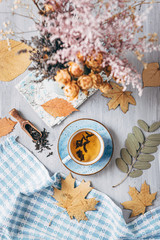 autumn warming tea on a wooden table with autumn tree leaves lying nearby