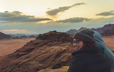 Girl smiling while watching the sunrise in the desert