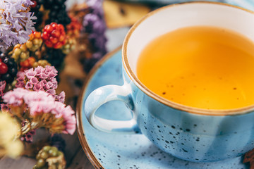autumn warming tea on a wooden table with autumn tree leaves lying nearby