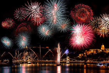 Obraz premium Colorful fireworks in Budapest august 20. at night - Buda Castle, Chain bridge, Danube and parliament in the background