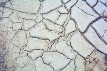 Dry mud ground, crack texture, granite gravel. Dry dirty soil. Cracks on clay