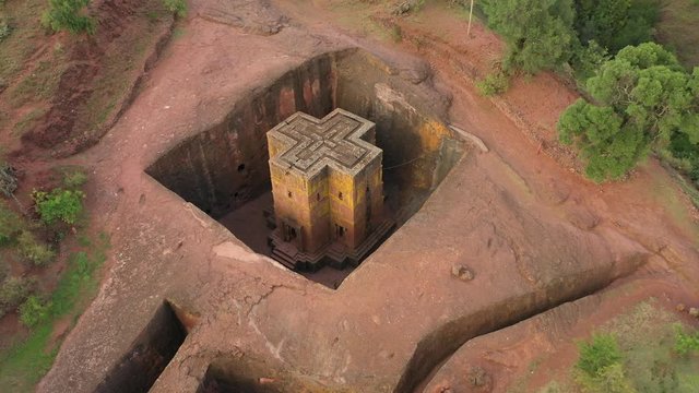 Tilting drone shot of spectacular rock carved Saint George church in Lalibela, culture and religion in Ethiopia 