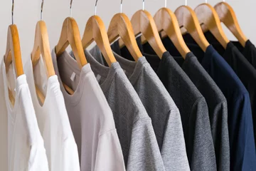 Fotobehang Close up of T-shirts on hangers, apparel background © Naypong Studio