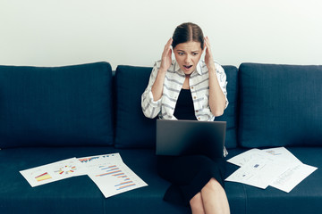 Young adult woman looking at documents with terrified face