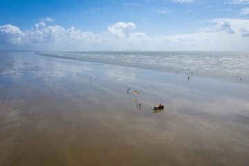 Aerial view of surfers walking to the sea on the beach of Pendine, Wales UK