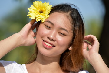 Attractive Asian Female Smiling With A Daisy
