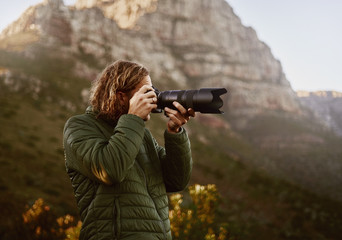 Young male photographer clicking photo from dslr camera