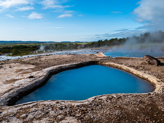 Blue geothermal pond at The Great Geysir, an active volcanic geyser in Southwestern Iceland