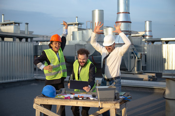 All three good looking workers drank beer while watching the video on the tablet, their joy filled the atmosphere as they celebrate their success