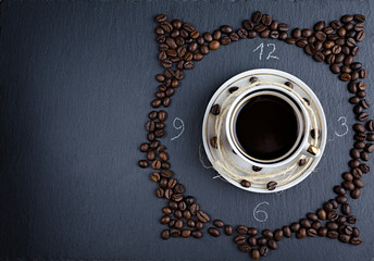a Cup of coffee on a stone Board with scattered coffee beans, an abstraction top view, flat lay