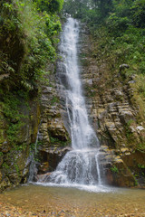 Fototapeta na wymiar Moderate sized waterfall and snow white water