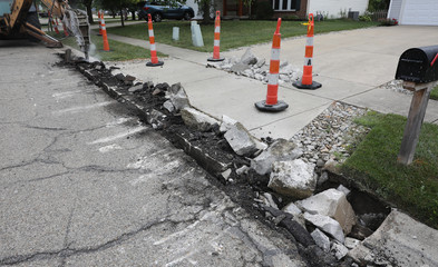 A driveway apron is torn up, the first step in replacing it.