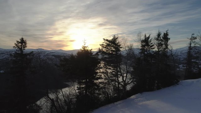 Drone flying over trees and revealing an amazing view over a beautiful fjord in Norway during sunset. Shot in Hopland, western Norway.  
