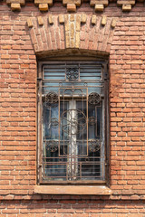 Window with metal bars in a brick house