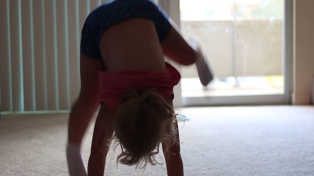 Little kid doing handstands in the living room of house playing around