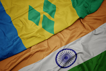 waving colorful flag of india and national flag of saint vincent and the grenadines.
