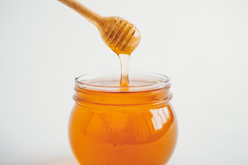 Honey in a glass and Honey scoop White background