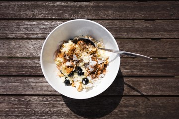 Healthy hot breakfast. Bowl of millet porridge with blueberries, coconut, walnuts and cinnamon. Still life. View from the top.