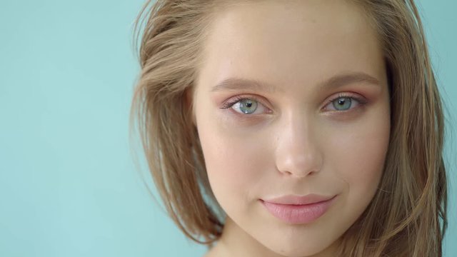 Girl in the studio on a bluebackground.Advertising, hair products, beauty salon, cosmetics, clothing. Fashion, boutique. Pink.