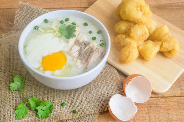 Porridge, chicken Porridge (congee) and Soft-boiled egg served in white bowl with deep-fried doughstick