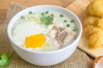 Porridge, chicken Porridge (congee) and Soft-boiled egg served in white bowl with deep-fried doughstick