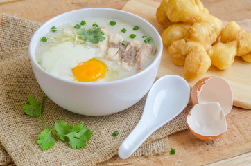 Porridge, chicken Porridge (congee) and Soft-boiled egg served in white bowl with deep-fried doughstick