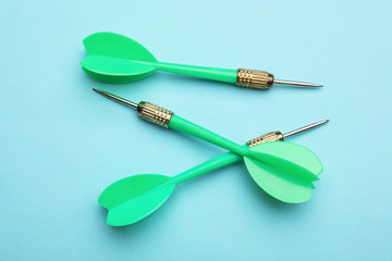 Green dart arrows on blue background, flat lay