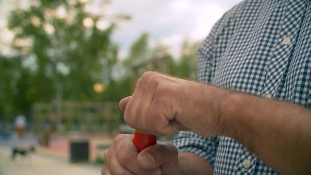 Brutal man angry illegally drinking beer in the park. He put the beer bottle into a paper bag