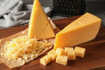 Grated and cut delicious cheese on board