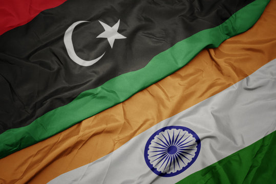 waving colorful flag of india and national flag of libya.