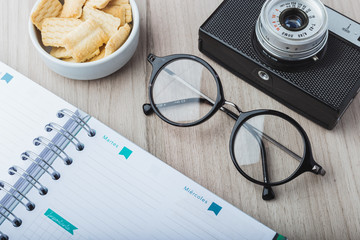 Woman glasses with planner, cookies and camera