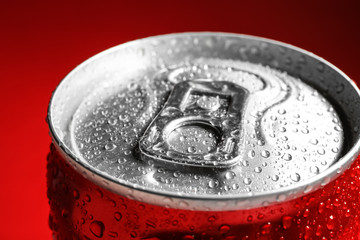 Wet closed can on red background, closeup